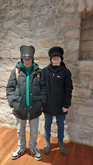Zwei Schüler tragen Kopfbedeckungen aus längst vergangener Zeit